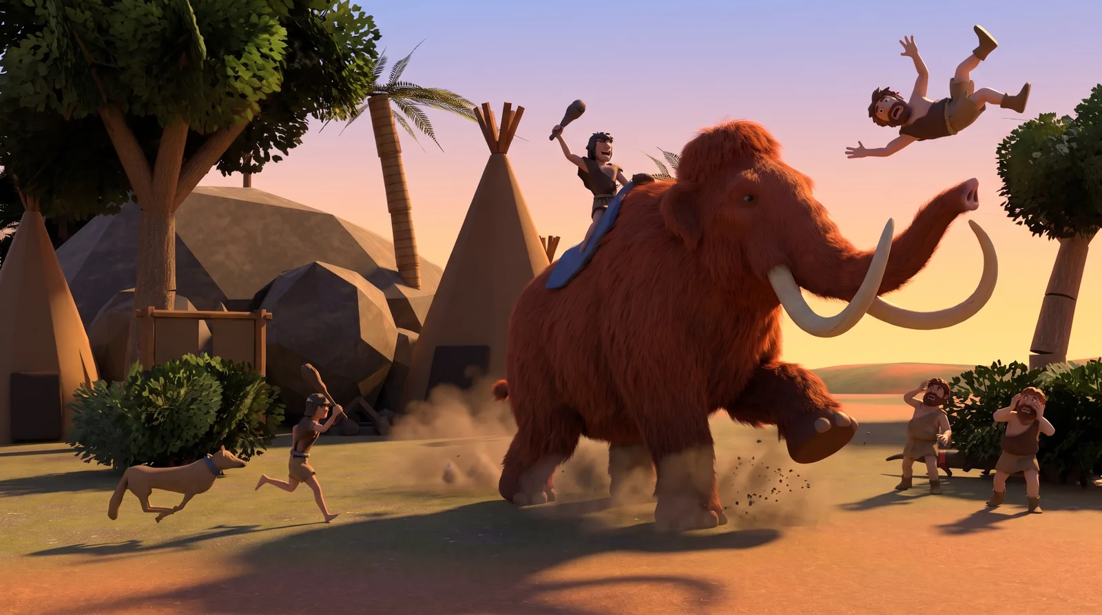 Key art at sunset: a caveman rides a charging woolly mammoth through a camp of hide tents, and another caveman flies through the air above it while the rest of the tribe scatters.
